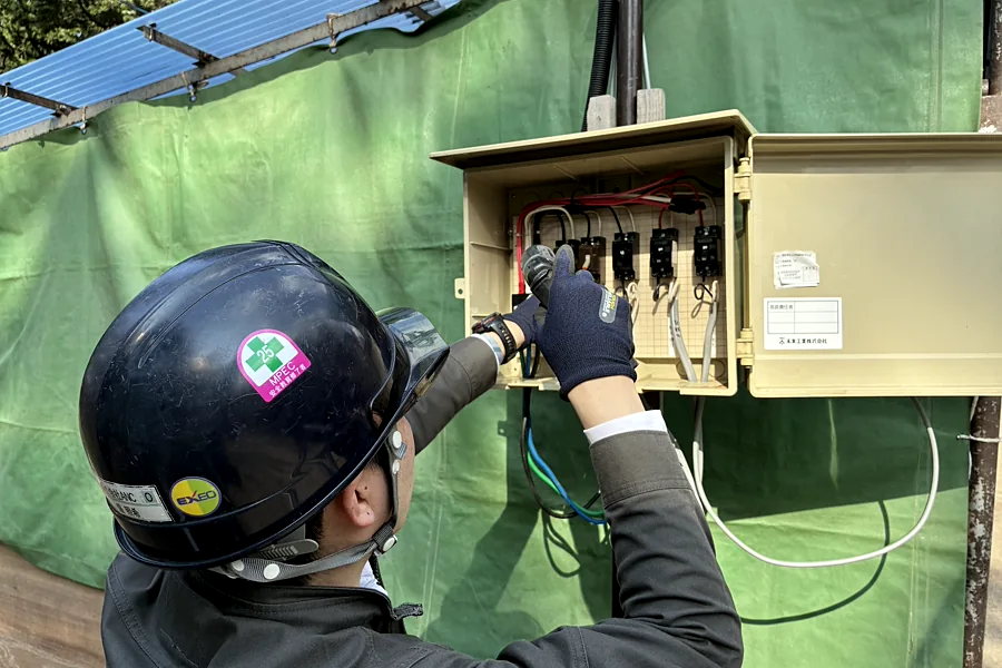 仮設の分電盤につなぎ込む作業